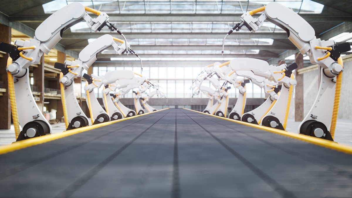 Interior of a modern automated factory with robotic arms and conveyor belt.