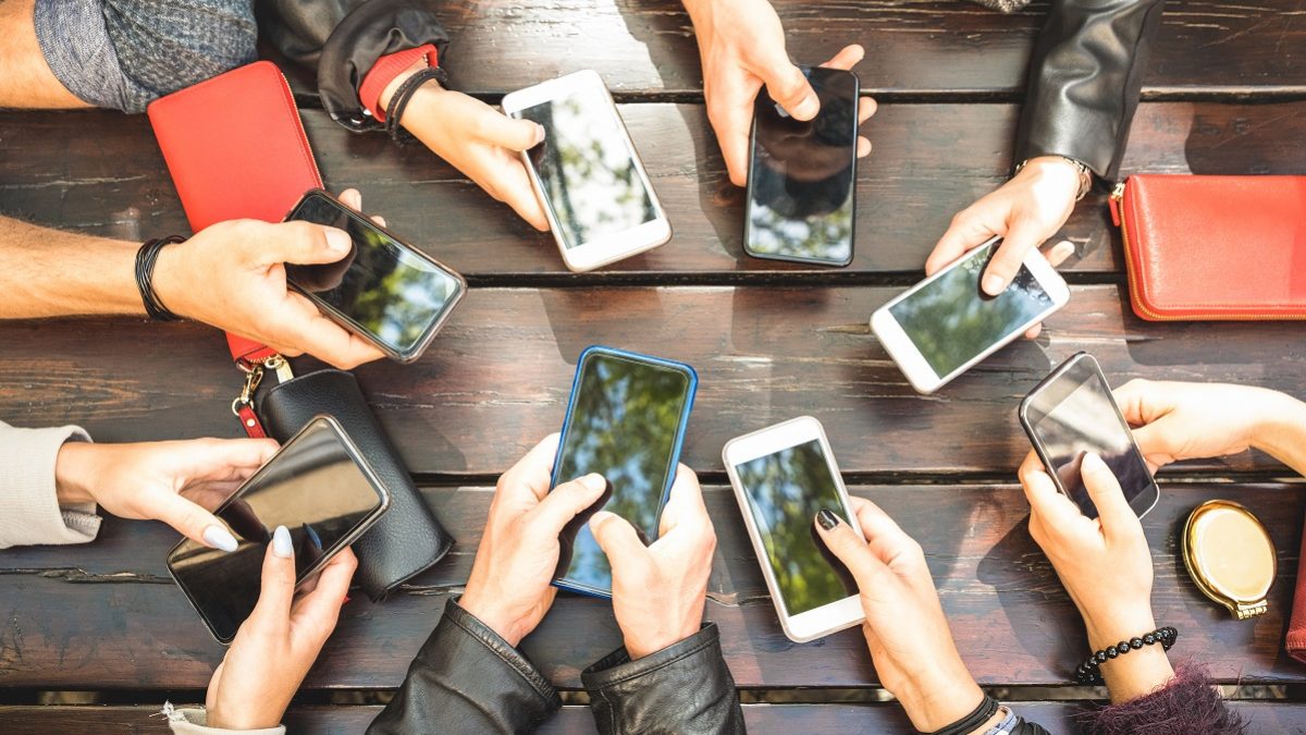 People group having addicted fun together using smartphones - Detail of hands sharing content on social network with mobile smart phones - Technology concept with millennials online with cellphones