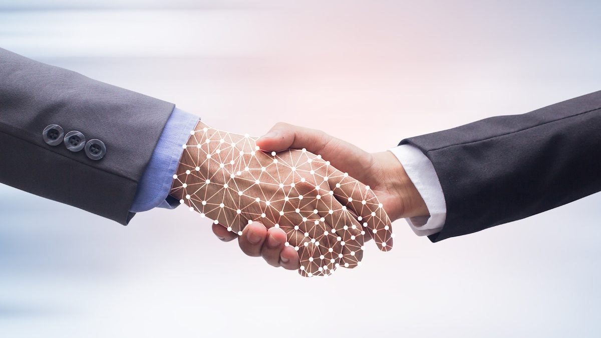 close up business man handshake with business artificial intelligence (AI) on motion blur background for future technology concept