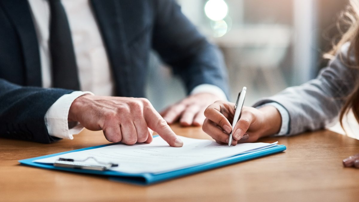 Closeup shot of two unrecognizable businesspeople going through paperwork in an office