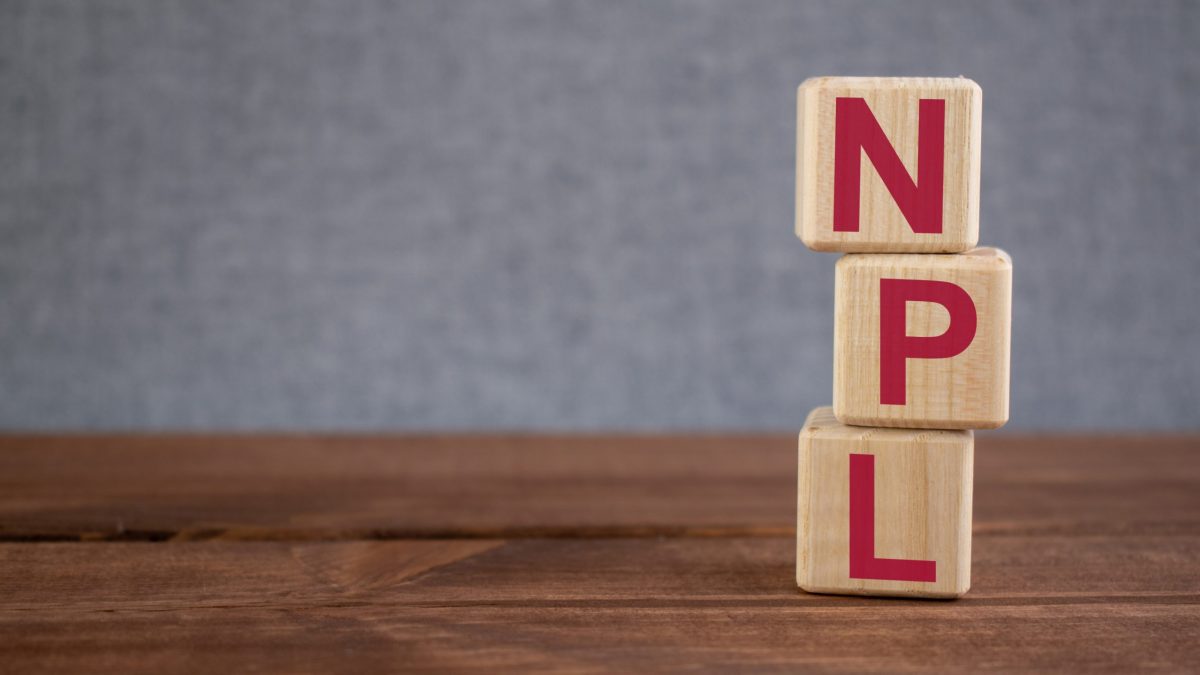 NPL (Non Performing Loan) acronym on wooden cubes on dark wooden backround. Business concept.