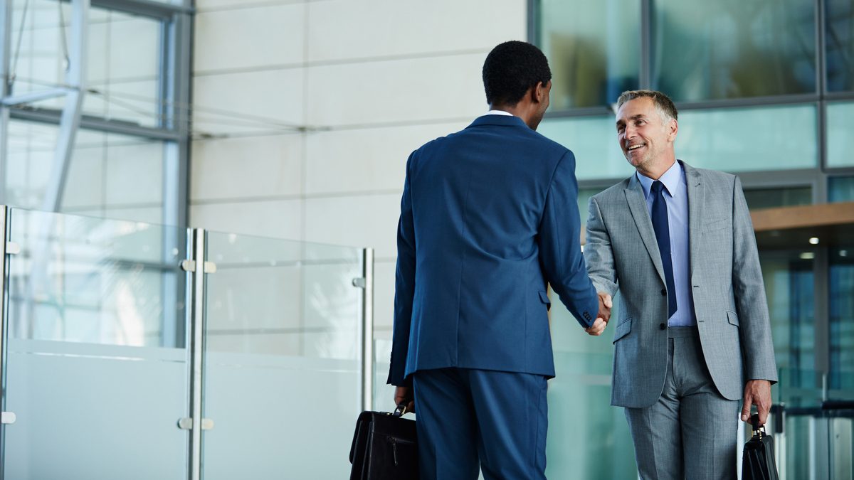 Shot of two businessmen shaking hands in the lobby of an office building