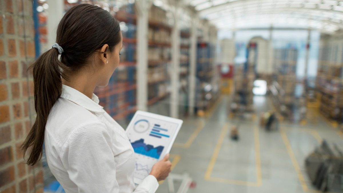 Business woman working on freight transportation and using a tablet computer to check stock at a warehouse