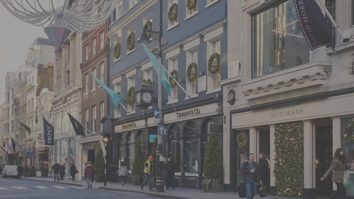 London, England - December 10, 2014: People walking past Christmas-decorated shops in Old Bond Street, London. Old Bond Street and New Bond Street house many luxury retailers, some of which can be seen here, such as Tiffany, DKNY, Chanel and David Morris.