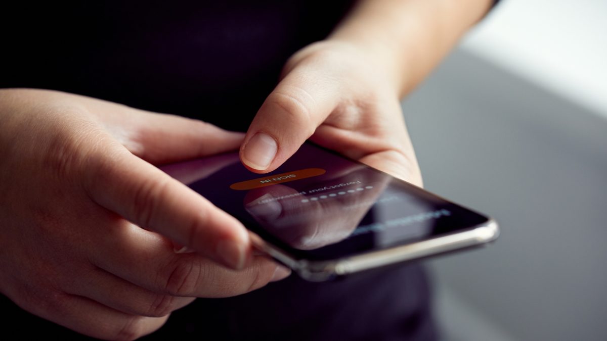 Woman signs up for banking with their mobile phone in the office