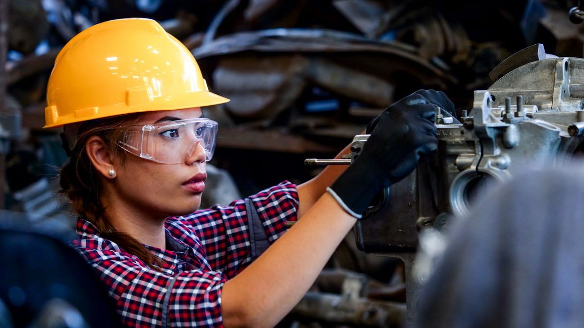 Young Asian Engineer woman  working with machine in factory.