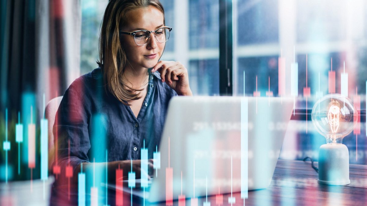 Young woman working at modern office.Technical price graph and indicator, red and green candlestick chart and stock trading computer screen background. Double exposure. Trader analyzing data (Young woman working at modern office.Technical price graph